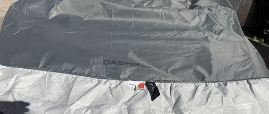 Close-up of a DaShield car cover showing the gray outer fabric and the soft white fleece inner lining