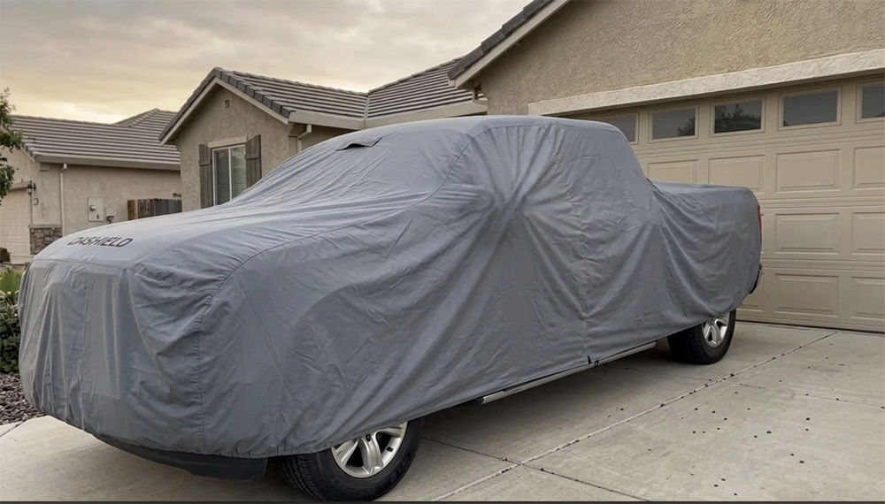 A gray DaShield car cover fitting snugly over a Ford F-150 in a Sacramento, California driveway