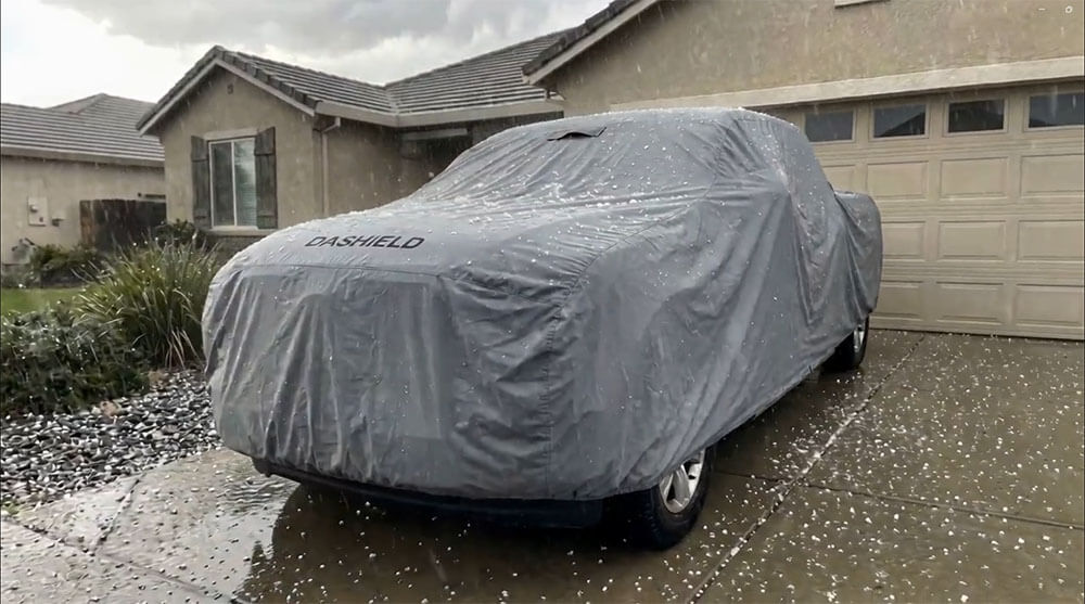 A DaShield car cover keeping a Ford F-150 dry during a rainstorm in a Sacramento, California driveway