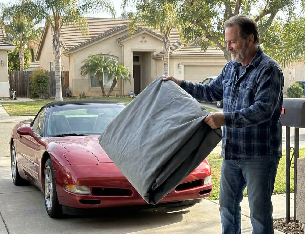 Owner folding a DaShield cover on a driveway