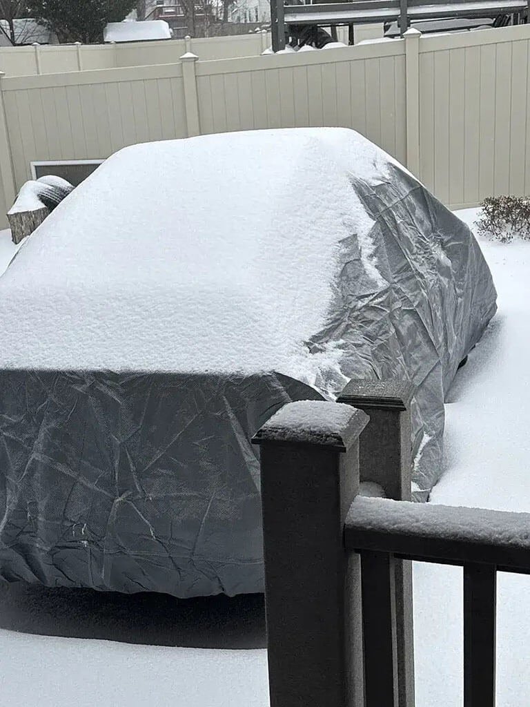 Car cover keeping a sedan protected through snowfall