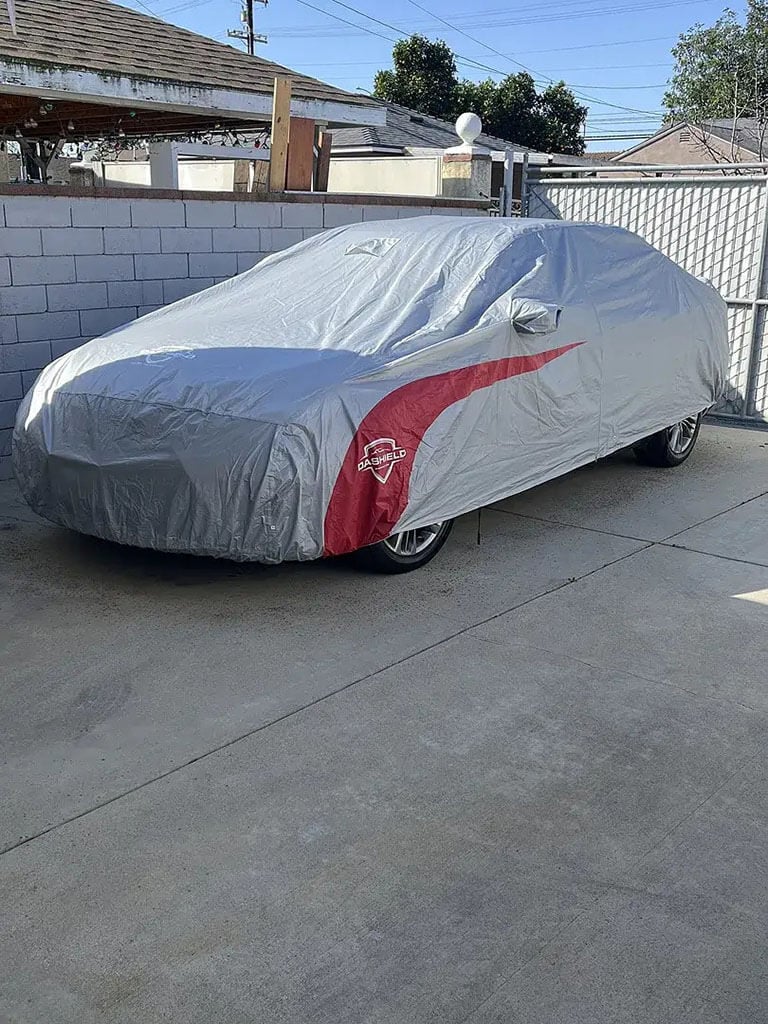 Car cover on a sedan parked on a city street