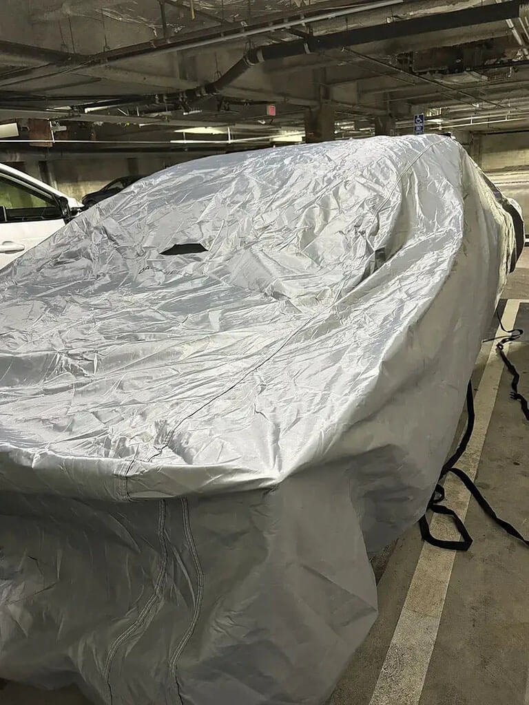 Fitted car cover in a parking garage