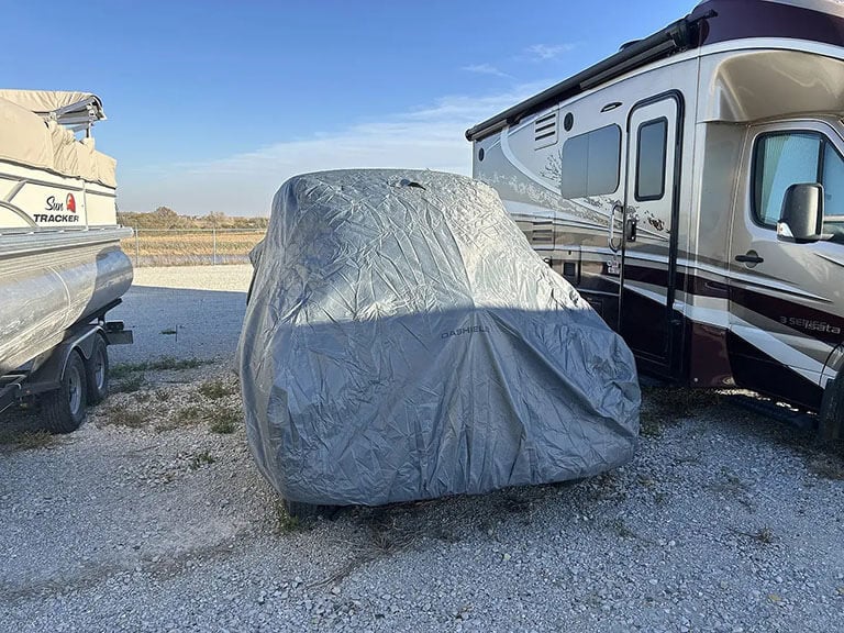 Heavy-duty cover protecting a vehicle in outdoor storage