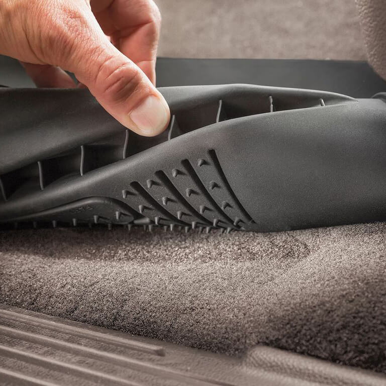 Rinsing a Husky Liners mat clean with water