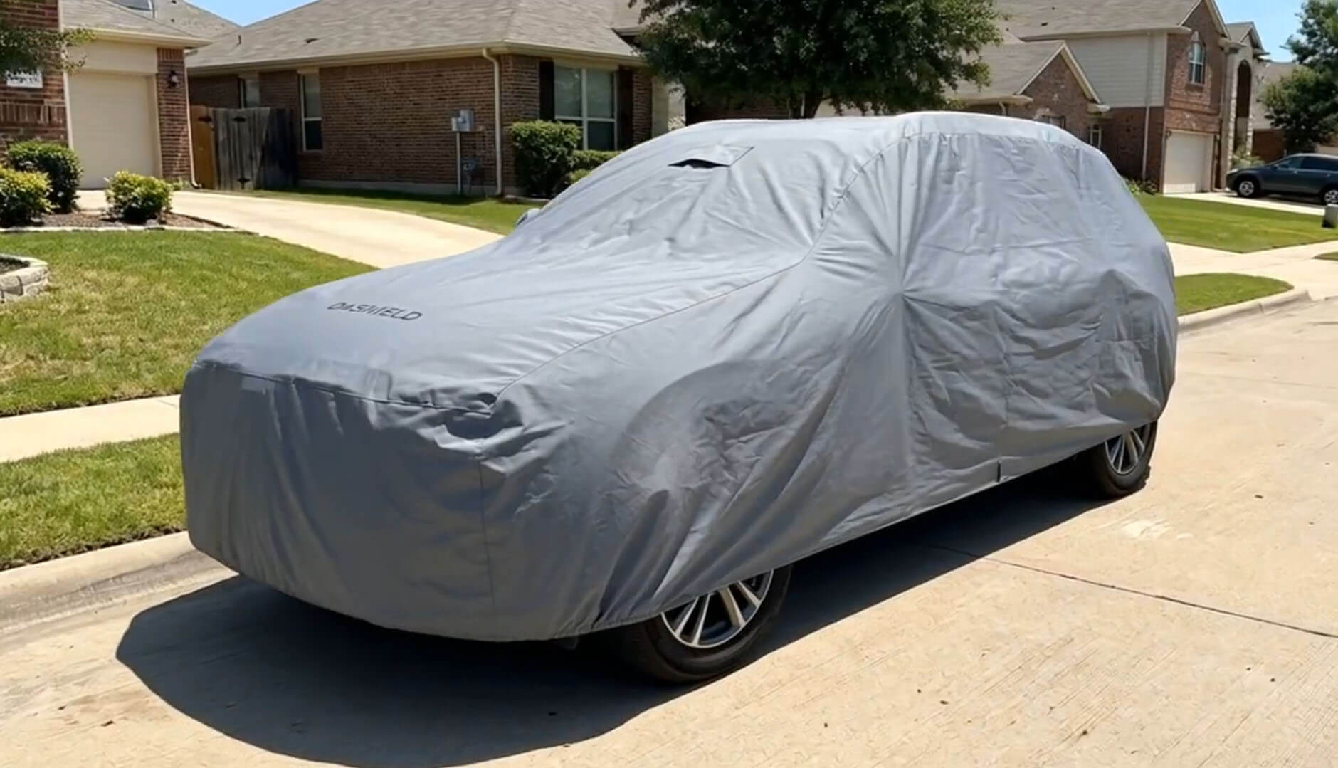 SUV under a DaShield cover in golden evening sunlight on a driveway